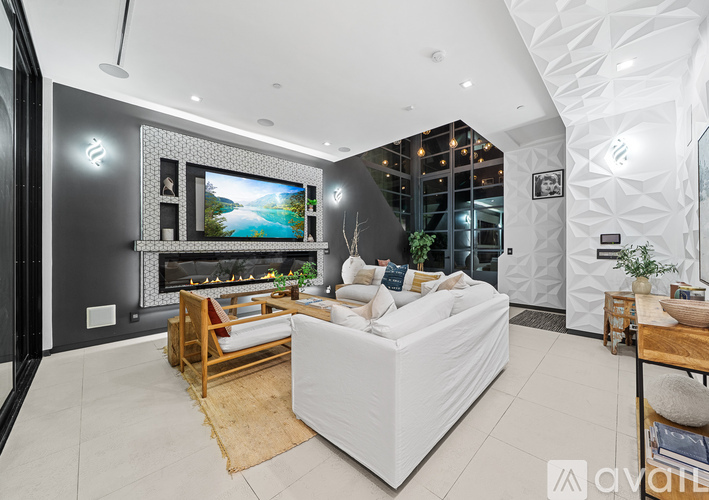 A modern living room with a large television and comfortable seating.