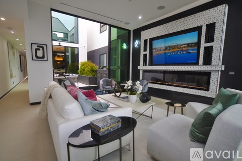 A modern living room with a large television and comfortable seating.