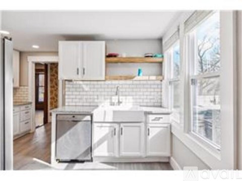 A kitchen with white cabinets and a white tiled backsplash.