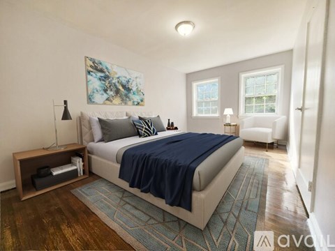 A bedroom with a large bed and a painting on the wall.