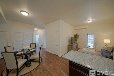 A well-lit living room with a dining table set for four.