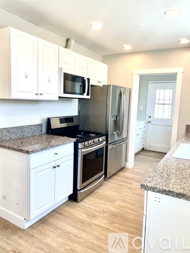 A kitchen with white cabinets and a granite countertop.