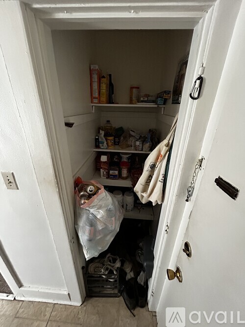 A small, white, open door with a black handle.