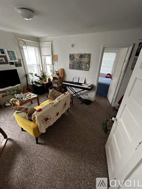 A living room with a yellow couch and a white door.