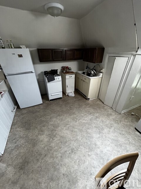 A small kitchen with a white refrigerator, white stove, and white cabinets.
