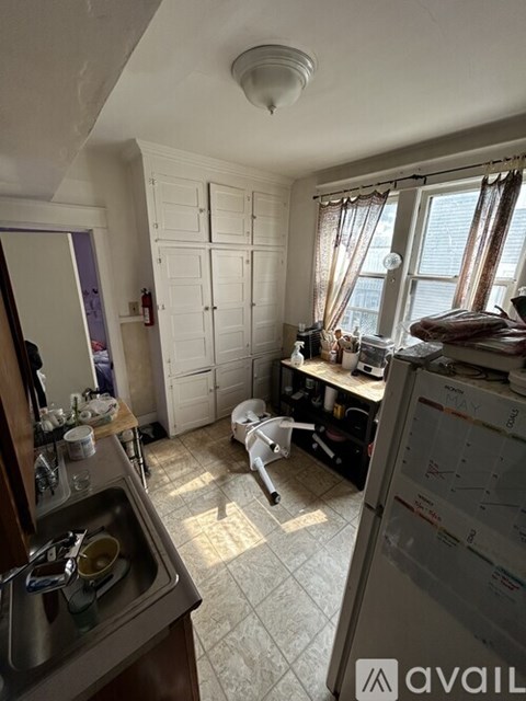 A kitchen with a sink and a refrigerator.