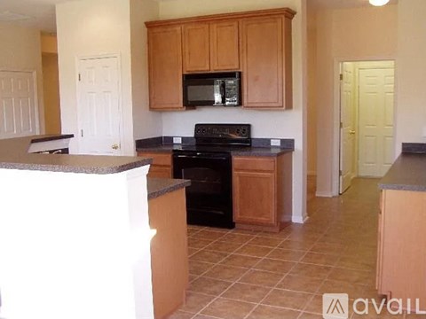A kitchen with wooden cabinets and a black stove top oven.