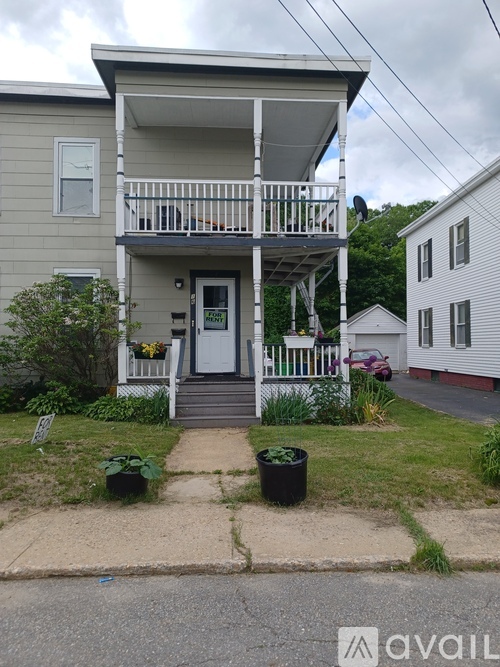 A two-story house with a porch and a "For Rent" sign.