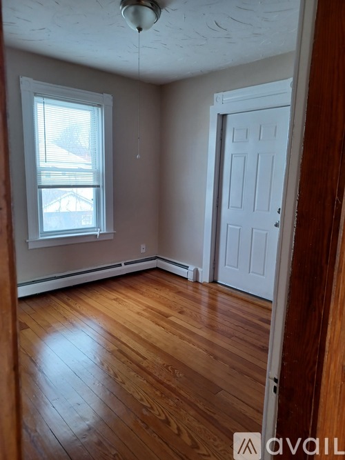 A room with wooden floors and a white door.