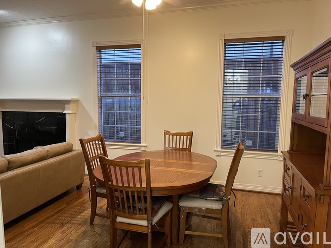 A room with a table, chairs, and a ceiling fan.