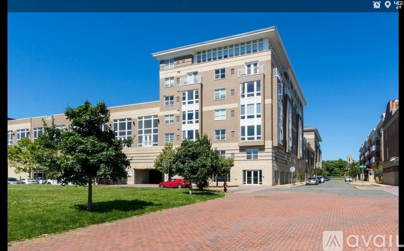 A large building with a red brick walkway in front of it.