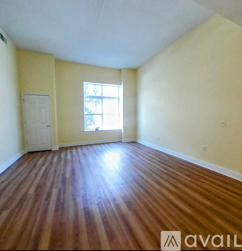 A room with wooden flooring and a window.