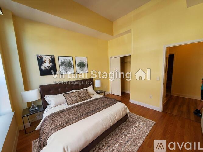 A bedroom with a bed, nightstand, and pictures on the wall.