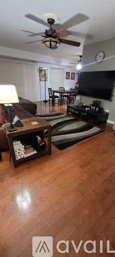 A living room with a brown couch and a ceiling fan.