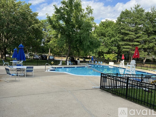 A pool area with a blue pool and a black fence.