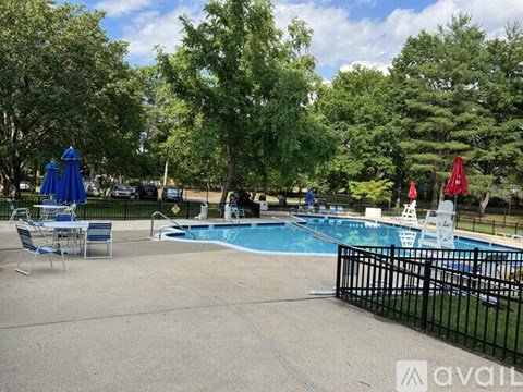 A pool area with a blue pool and a black fence.
