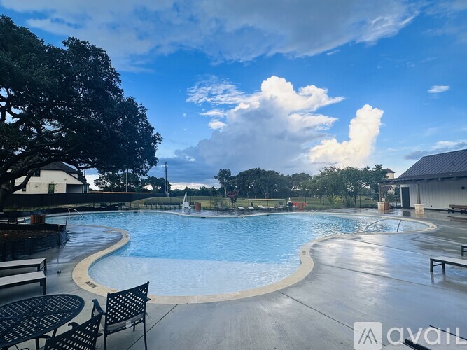 A large outdoor swimming pool with a table and chairs around it.