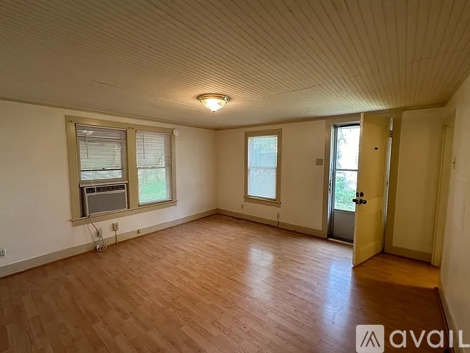 Empty room with wooden floors and white walls.