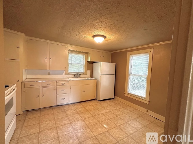 A kitchen with white appliances and beige cabinets.