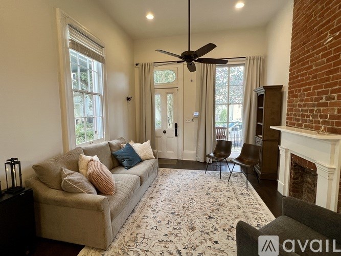 A living room with a couch, chairs, and a fireplace.