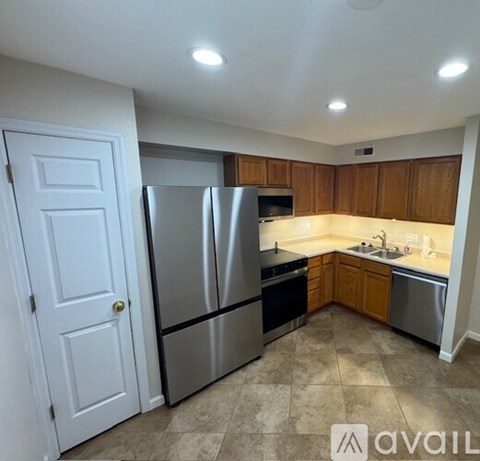 A kitchen with a refrigerator, oven, and sink.