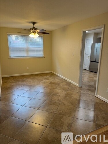A room with tile flooring and a ceiling fan.