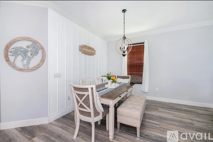 A dining room with a wooden table and chairs.
