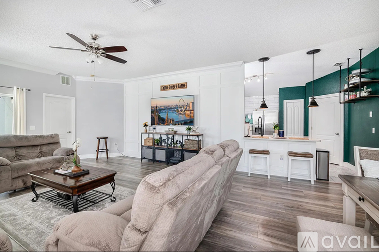A living room with a couch, a coffee table, and a painting on the wall.