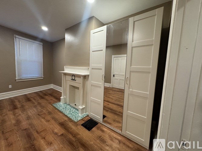 A room with a fireplace and wooden floors.