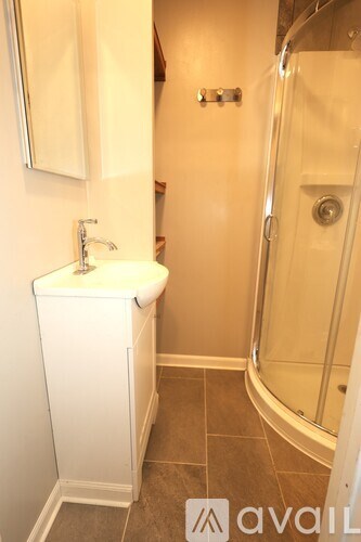 A bathroom with a sink, mirror, and shower.