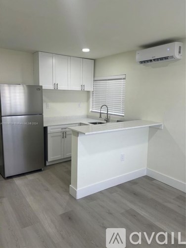 A kitchen with a stainless steel refrigerator and a white countertop.