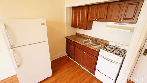 A kitchen with a refrigerator, oven, and microwave.