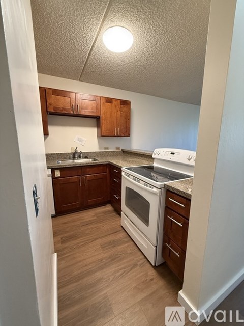 A kitchen with white appliances and wooden cabinets.
