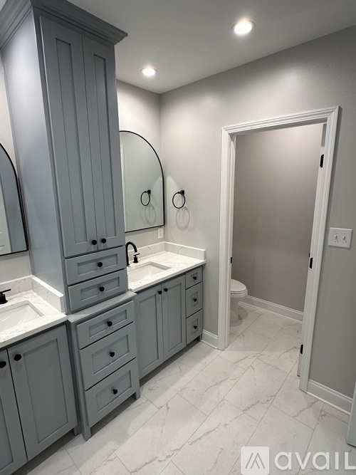 A bathroom with a sink, mirror, and cabinets.