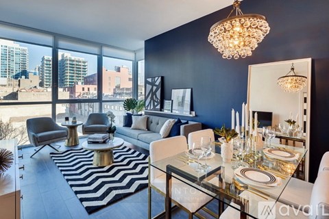 A modern living room with a glass table and a chandelier.