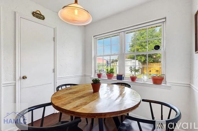 A dining room with a round wooden table and chairs.