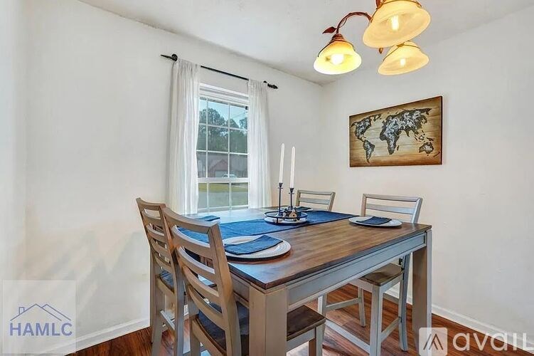 A dining room with a wooden table and chairs.