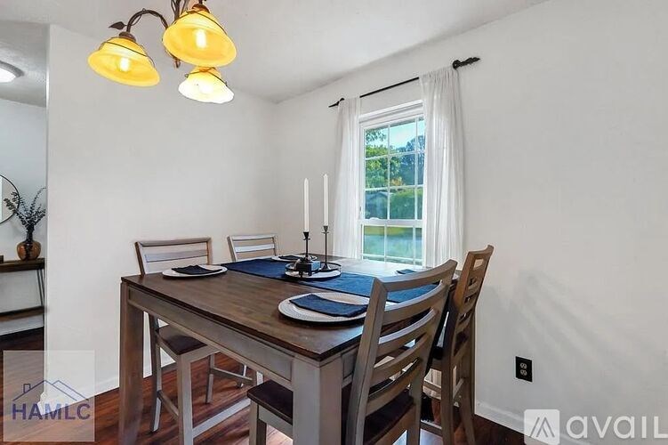 A dining room with a wooden table and chairs.