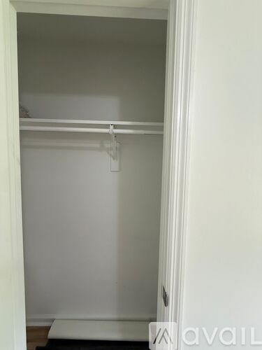 A white closet with a black mat on the floor.