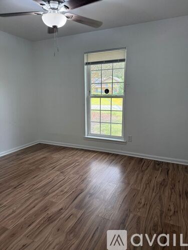 A room with wooden flooring and a window.