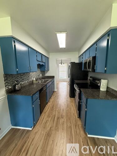 A kitchen with blue cabinets and a black countertop.