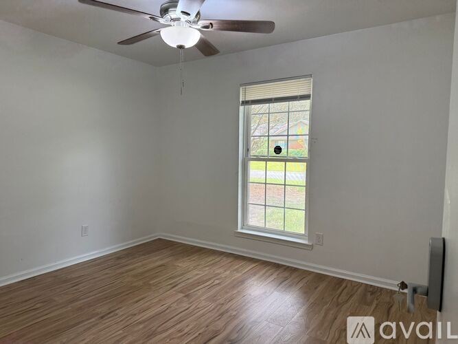 A room with a ceiling fan and a window.
