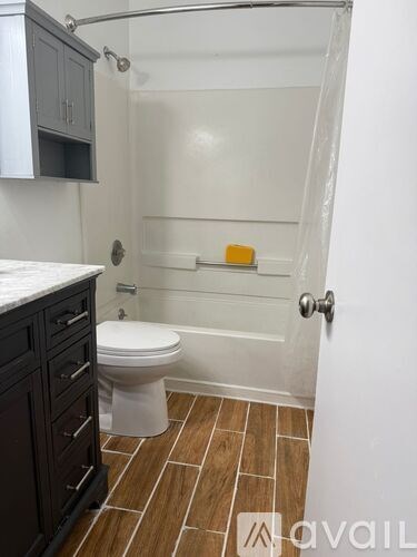 A bathroom with a toilet, a bathtub, and a shower.