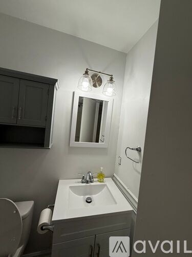A bathroom with a sink, mirror, and toilet.