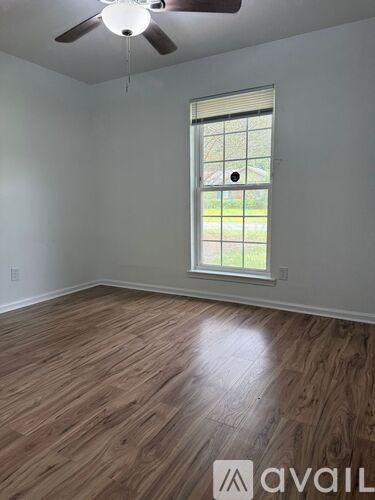 A room with a window and a ceiling fan.