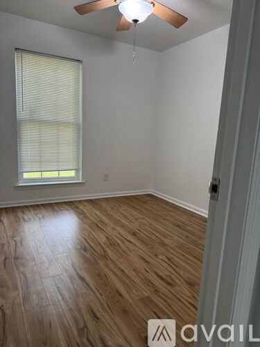 A room with wooden flooring and a ceiling fan.