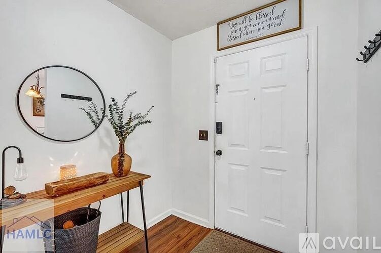 A white door is in a room with a table and a mirror.