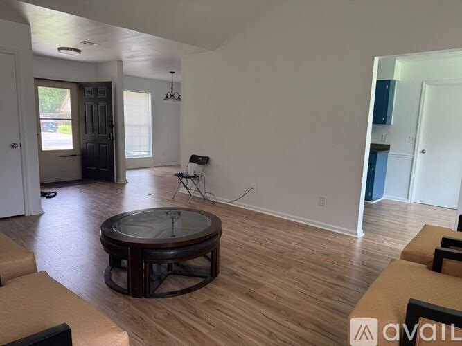 A living room with a glass table and brown couches.