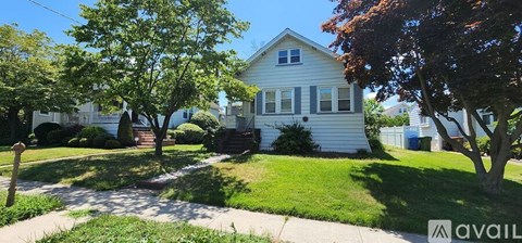 A house with a white front yard and a tree in front of it.