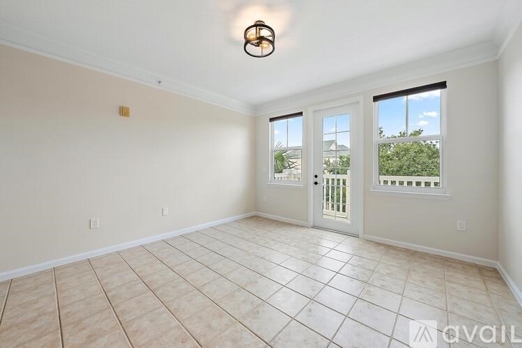 A room with a tiled floor and a sliding glass door leading to a balcony.
